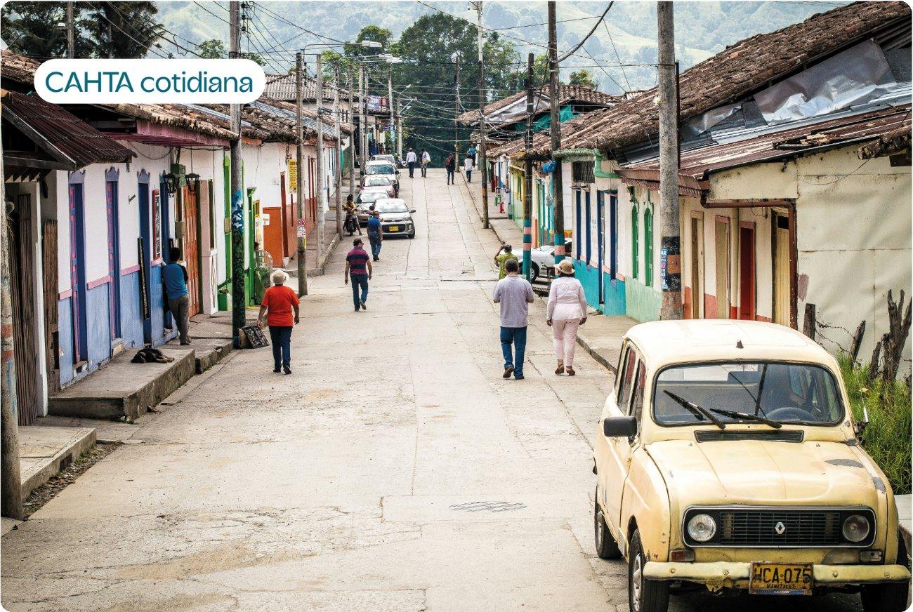 Calle de un pueblo colombiano con un carro amarillo, con la etiqueta CAHTA cotidiana