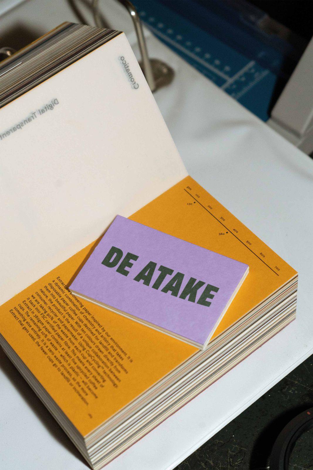 Tarjeta lila de De Atake sobre un libro