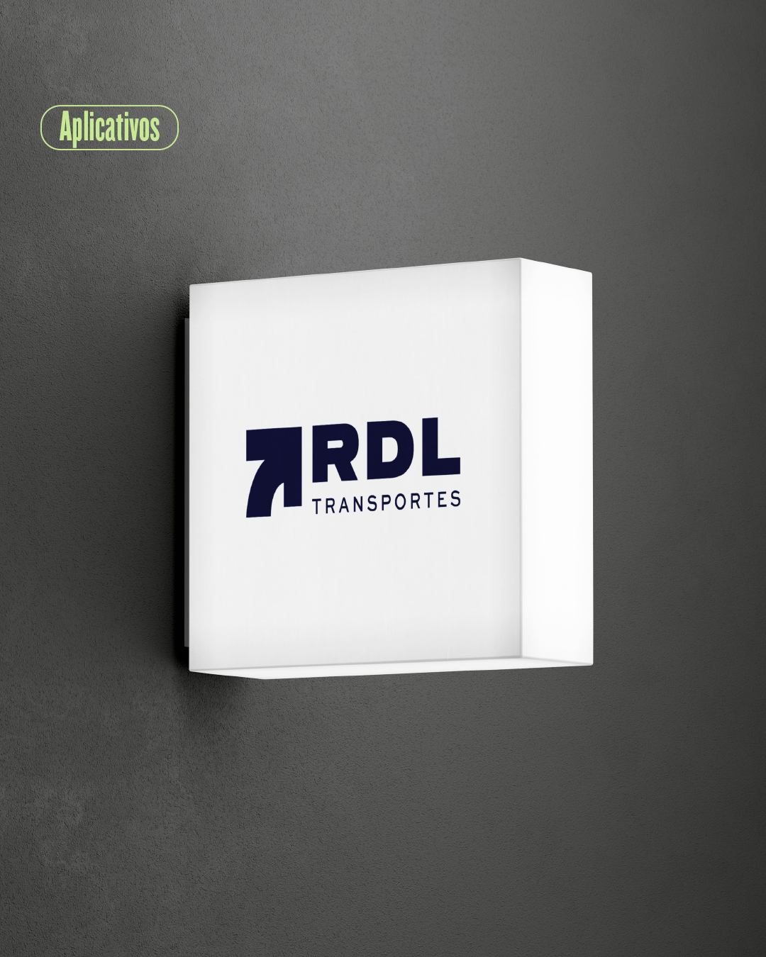 Letrero blanco con el logo de RDL Transportes sobre una pared oscura